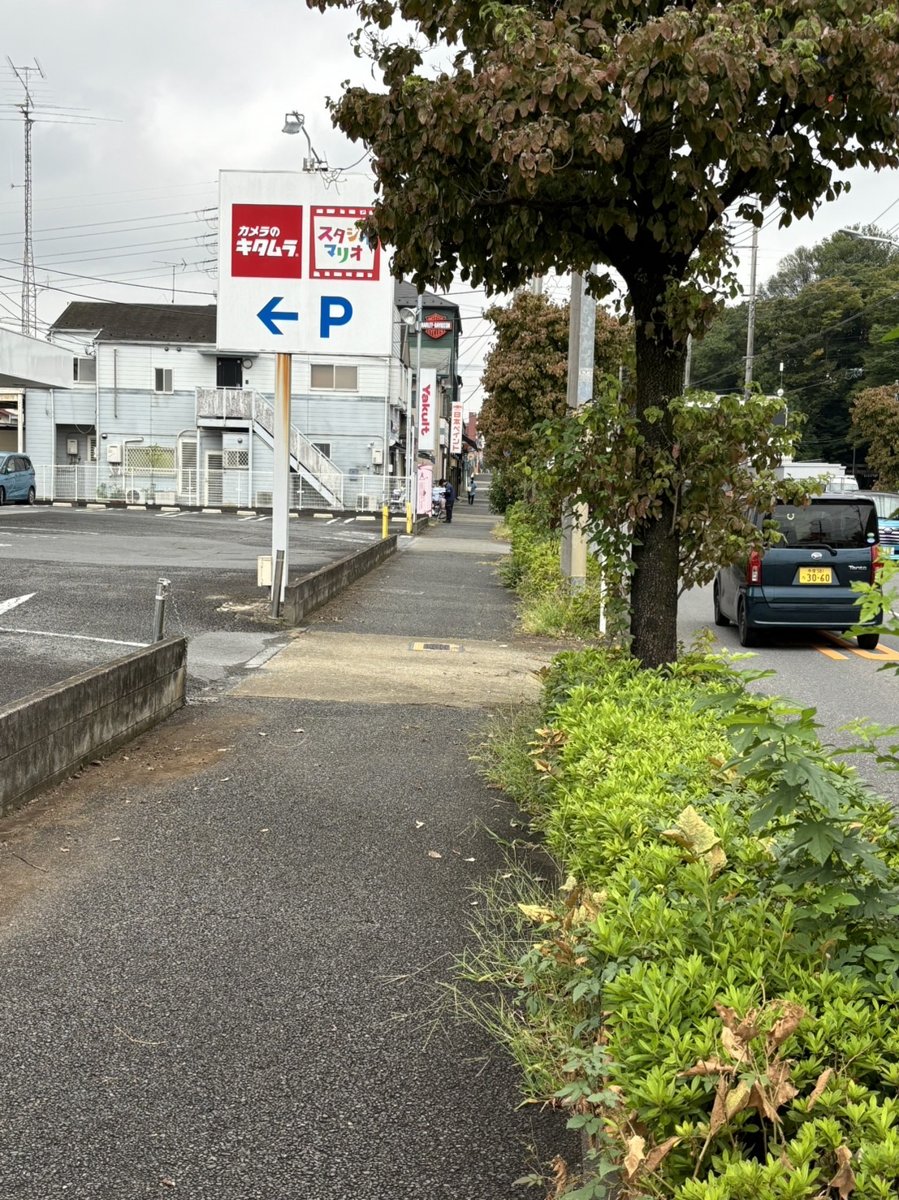 臨時駐車場から店舗へ向かう途中のカメラのキタムラの看板